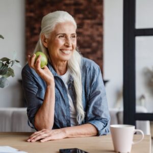 mature woman smiling holding apple