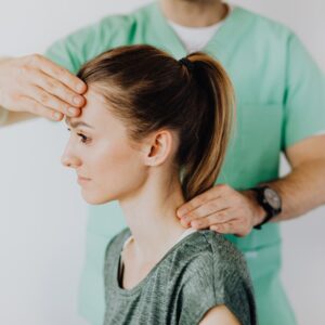 Chiropractor adjusts woman's neck while holding her head