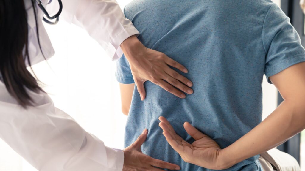 Chiropractor feels man's back
