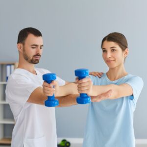 Woman lifts dumb bell weights with chiropractor
