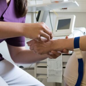 Female phlebotomist inserts IV