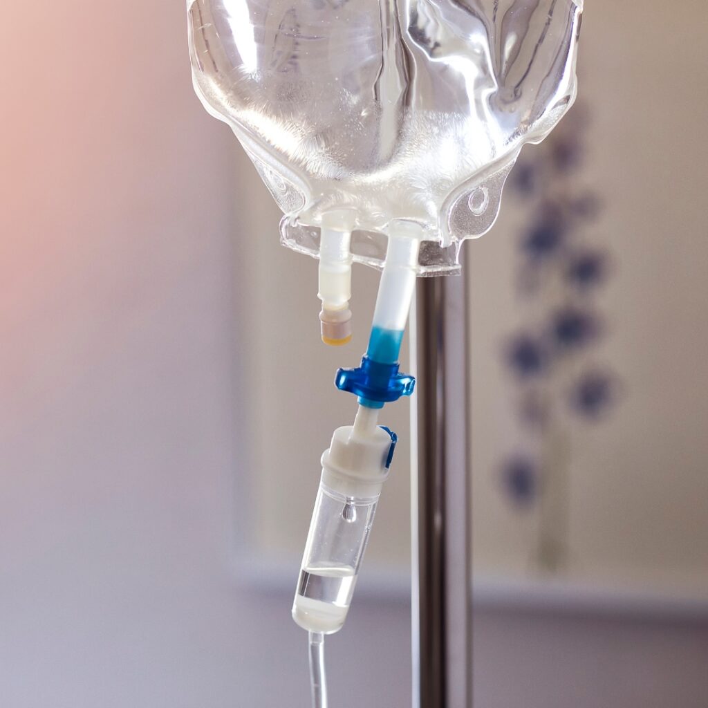 Close-up of an IV drip bag with clear fluid, ready for intravenous administration.