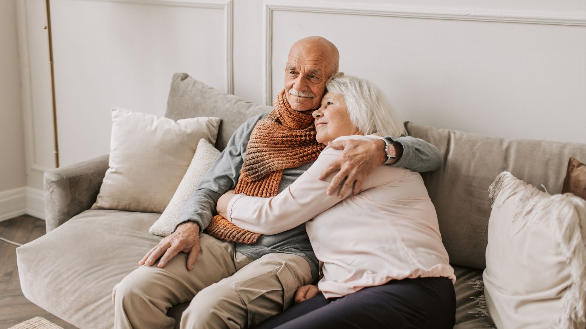 An older couple cuddling on a sofa.