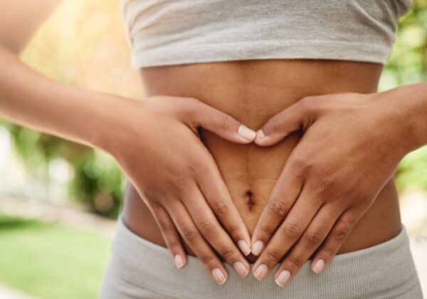 a woman making a heart over her stomach
